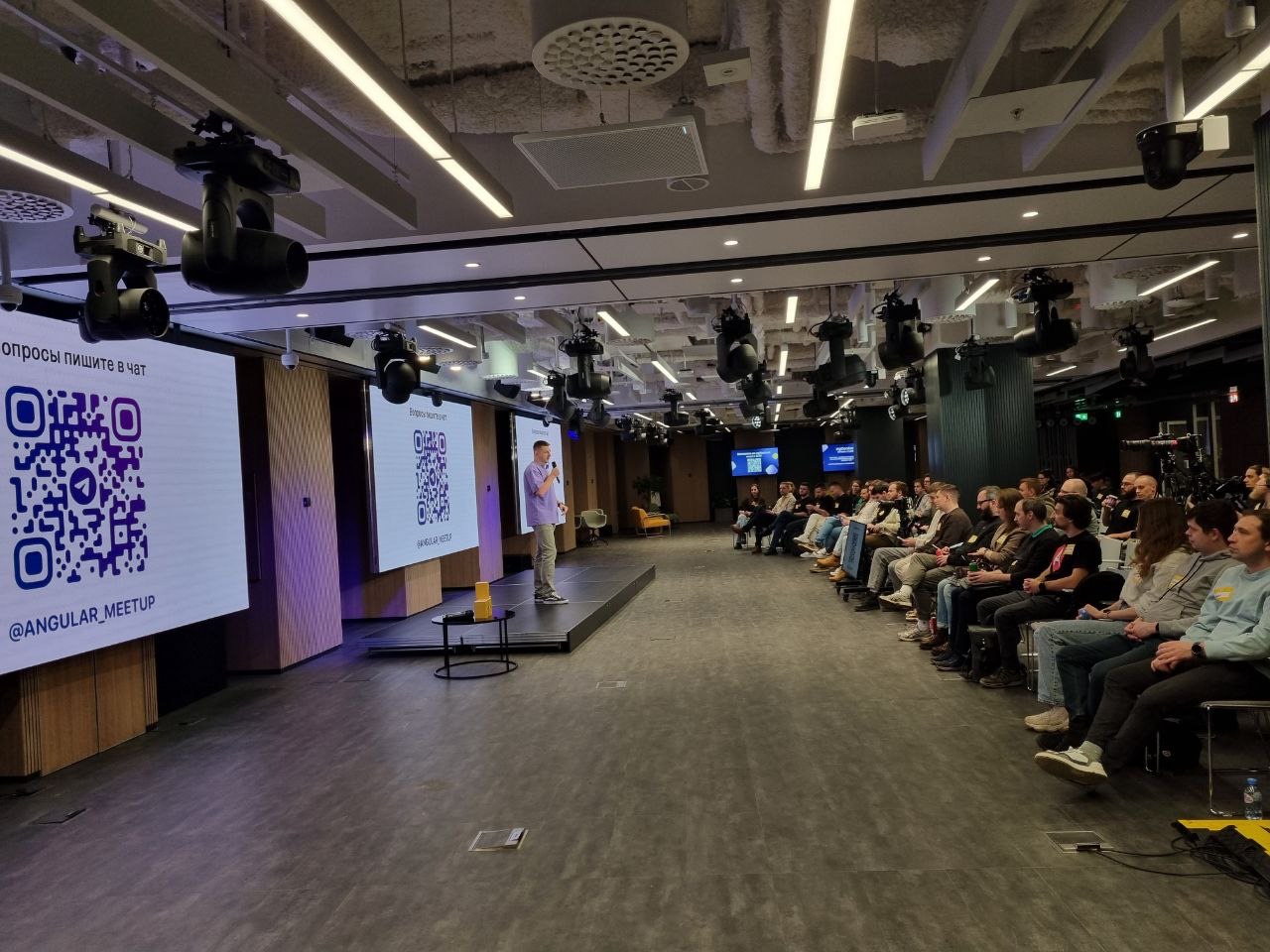 Зал во время Angular Meetup: спикер на сцене и слушатели